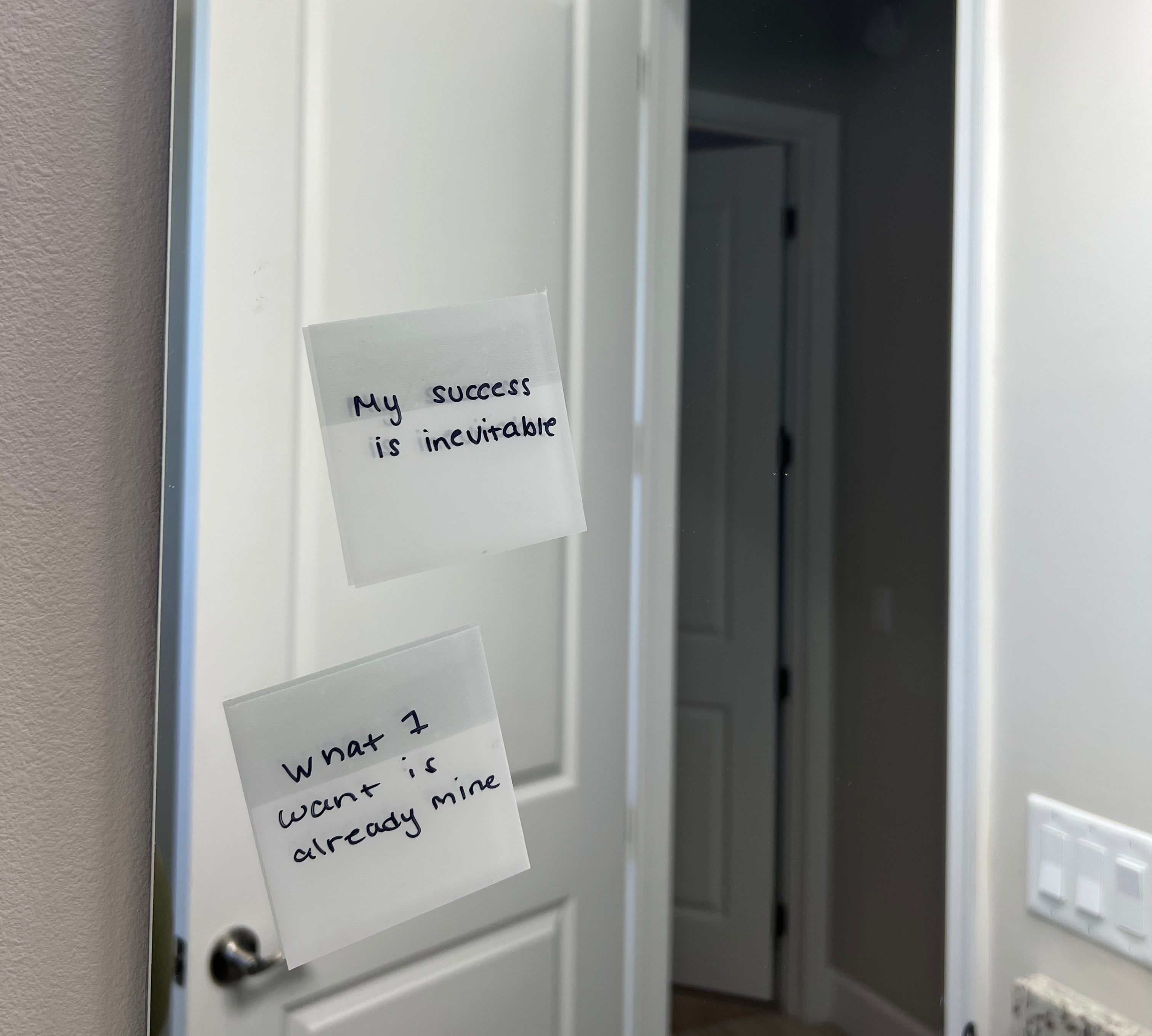 Transparent sticky notes with affirmations displaying on bathroom mirror