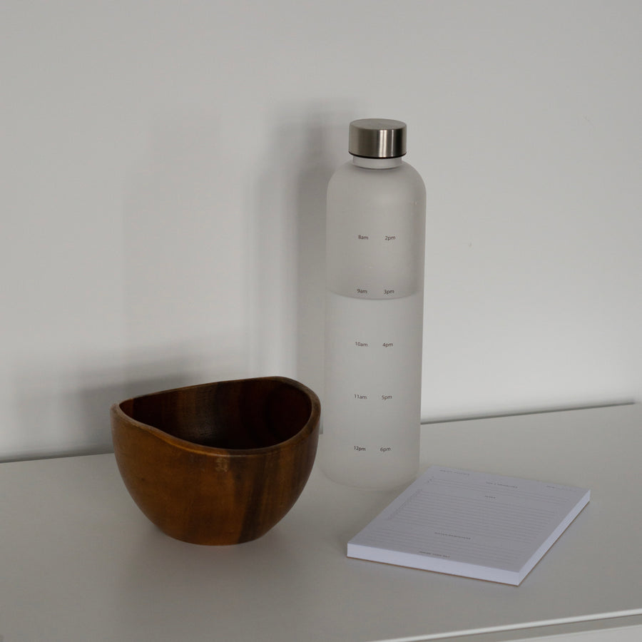 Daily Focus Notepad and Water Tracking Bottle on off-white table